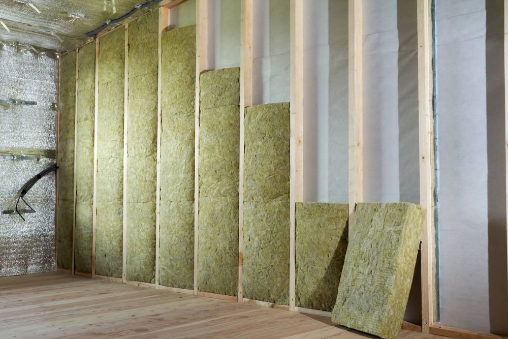 Interior view of a room with insulation visible on the walls, paired with polished wood floors for a cozy atmosphere.