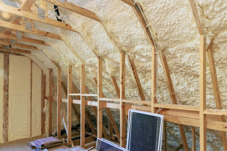 Insulation installed in an attic, featuring wood framing and insulation materials, highlighting an insulation installation service.
