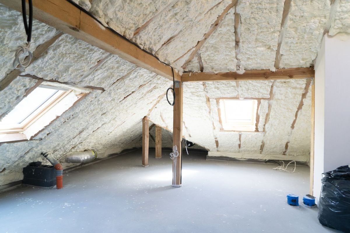 An attic featuring insulation materials and a ladder, representing an insulation installation service.