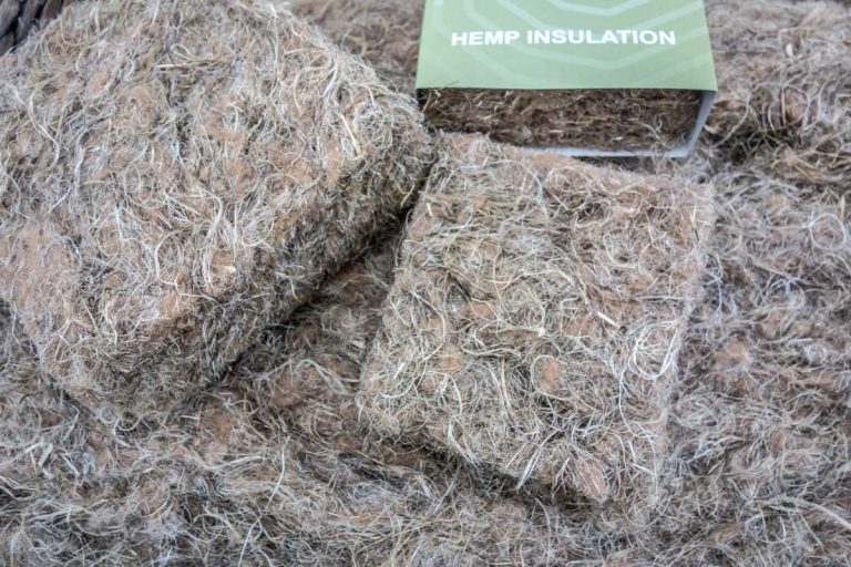 A pile of hay with a sign reading "Hemp Insulation" promoting eco-friendly insulation services.